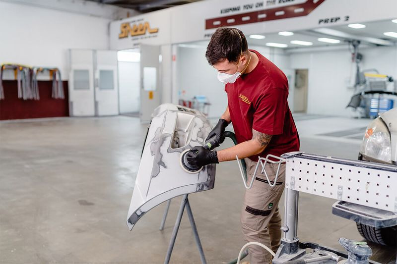 Example image of a Sheen Pane Services team member repairing a vehicle door.